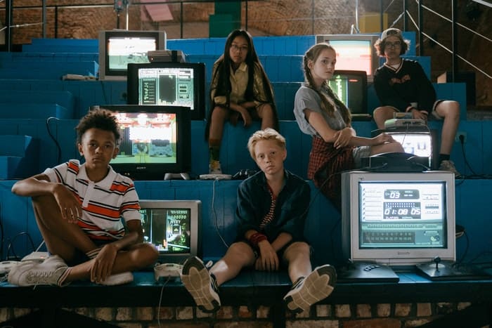 stressed out kids sitting in between tv sets